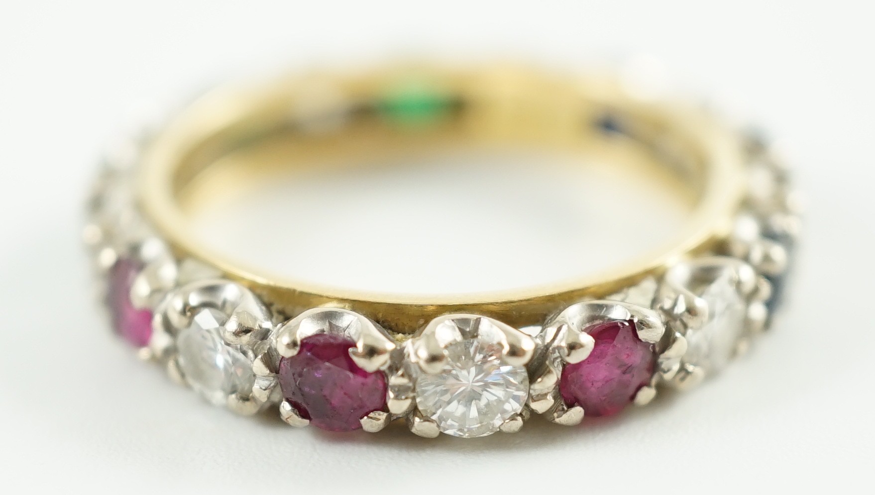 A modern 18ct gold, emerald, sapphire, ruby and diamond set full eternity ring